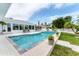 Inviting pool area with outdoor seating, lush landscaping, and clear blue water, perfect for relaxation at 3941 14Th Ne Ln, St Petersburg, FL 33703