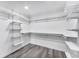 Walk-in closet features a modern, open design with shelving and gray wood-look flooring at 3941 14Th Ne Ln, St Petersburg, FL 33703