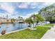 Serene waterfront view with lush green lawn, palm trees, and easy access to the water for boating at 3941 14Th Ne Ln, St Petersburg, FL 33703