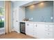 Chic bar area with wine refrigerator, ample storage, and stylish tiled backsplash at 4104 Las Palmas Way, Sarasota, FL 34238