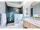 Stylish bathroom featuring blue tile in shower and patterned wallpaper at 4104 Las Palmas Way, Sarasota, FL 34238