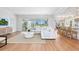 Bright and spacious living room with hardwood floors, white sofa, and access to outdoor patio at 4104 Las Palmas Way, Sarasota, FL 34238