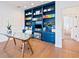 Home office featuring custom blue built-ins and a glass desk at 4104 Las Palmas Way, Sarasota, FL 34238
