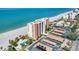 Breathtaking aerial view showcasing the beachfront condo building, pool, parking and pristine sandy beach at 4401 Gulf Of Mexico Dr # 907, Longboat Key, FL 34228