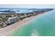 Aerial view of condos along beach with scenic coastline, clear turquoise water, and tropical island at 4401 Gulf Of Mexico Dr # 907, Longboat Key, FL 34228