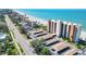 Aerial view of condos with covered parking, tropical landscaping, and beach access at 4401 Gulf Of Mexico Dr # 907, Longboat Key, FL 34228