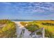Charming wooden steps lead down to the beach with lush greenery and stunning ocean views at 4401 Gulf Of Mexico Dr # 907, Longboat Key, FL 34228