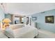 Light and airy bedroom boasts two beds, balcony access with gorgeous ocean views, and light blue wall coloring at 4401 Gulf Of Mexico Dr # 907, Longboat Key, FL 34228