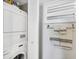 Neat laundry area with stacked washer and dryer, plus handy shuttered storage and towel rack at 4401 Gulf Of Mexico Dr # 907, Longboat Key, FL 34228