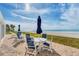 Relaxing outdoor patio with comfortable seating and umbrellas, overlooking the stunning beach and ocean views at 4401 Gulf Of Mexico Dr # 907, Longboat Key, FL 34228