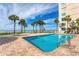 Beautiful outdoor pool area with chairs, palm trees, and ocean views for relaxation and enjoyment at 4401 Gulf Of Mexico Dr # 907, Longboat Key, FL 34228