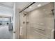 Shower with glass door, grab bar, rainfall shower head, and tile surround, next to ocean view at 4401 Gulf Of Mexico Dr # 907, Longboat Key, FL 34228