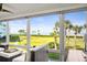 Bright sun room featuring comfortable seating with views of the water and palm trees at 4600 Gulf Of Mexico Dr # 201, Longboat Key, FL 34228