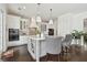 White kitchen island with seating, storage, and marble countertop plus a view into the dining room at 471 Gilman N Ct, St Petersburg, FL 33716