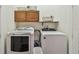 Well-equipped laundry room with a washer, dryer, and overhead cabinets for storage at 471 Gilman N Ct, St Petersburg, FL 33716