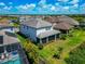 Aerial view of a neighborhood featuring a two-story home with pool, screened lanai, and a gray roof at 4881 Antrim Dr, Sarasota, FL 34240