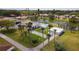 Aerial view of community pool, shuffleboard courts, parking, and nearby lake at 5053 Live Oak Cir, Bradenton, FL 34207