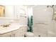 Clean bathroom with a single sink vanity, toilet, and a shower-tub combo with green-leaf shower curtain at 5053 Live Oak Cir, Bradenton, FL 34207