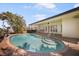 Backyard pool with brick coping and steps, complemented by landscaping and patio at 516 71St St, Holmes Beach, FL 34217