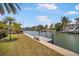Idyllic waterfront featuring a private dock with seating and well-maintained grassy banks under a clear blue sky at 516 71St St, Holmes Beach, FL 34217