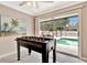 A well-lit recreation space with a foosball table and view of the pool through sliding glass doors at 5307 1St Avenue Nw Dr, Bradenton, FL 34209