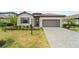 Charming single-story home with a well-manicured lawn, paver driveway, and neutral color palette at 5406 Coral Reef Way, Lakewood Ranch, FL 34211