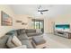 Bright living area with comfortable seating, ceiling fan and sliding glass doors at 5406 Coral Reef Way, Lakewood Ranch, FL 34211