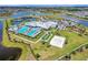 Aerial view of the community featuring pools, tennis courts, bocce ball, and a sand volleyball court at 5406 Coral Reef Way, Lakewood Ranch, FL 34211
