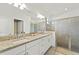 Bathroom featuring a double sink vanity with granite countertops and a glass shower at 5406 Coral Reef Way, Lakewood Ranch, FL 34211