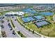 Aerial view of a community featuring a clubhouse, tennis courts, and a lush landscape at 5406 Coral Reef Way, Lakewood Ranch, FL 34211