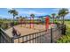 Community playground featuring swings, slides, and climbing structures in a fenced, safe area at 5406 Coral Reef Way, Lakewood Ranch, FL 34211