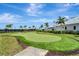 Well-maintained putting green surrounded by palm trees and lush landscaping for recreational use at 5406 Coral Reef Way, Lakewood Ranch, FL 34211