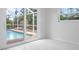 Bright bedroom with white carpet, natural light, and sliding door access to the pool at 5523 Scotia Pl, Sarasota, FL 34231