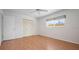 Bright bedroom features wood flooring, a window with blinds, and a closet with folding doors at 5523 Scotia Pl, Sarasota, FL 34231