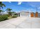 Beautifully landscaped front yard with lush greenery, tall palm trees, and a spacious driveway leading to a two-car garage at 5523 Scotia Pl, Sarasota, FL 34231