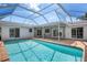 Inviting backyard swimming pool with a screened enclosure, poolside patio, and lush greenery for ultimate relaxation at 5523 Scotia Pl, Sarasota, FL 34231