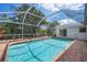 Refreshing in-ground pool surrounded by brick pavers and a screened enclosure offering serene outdoor enjoyment at 5523 Scotia Pl, Sarasota, FL 34231