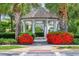 A charming white gazebo surrounded by vibrant red flowers offering a beautiful outdoor space at 5532 River Sound Ter, Bradenton, FL 34208