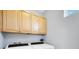 Laundry room featuring modern appliances and overhead cabinetry for storage at 5532 River Sound Ter, Bradenton, FL 34208