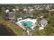 Aerial view of a community pool featuring lounge areas, a playground, and lush landscaping at 5532 River Sound Ter, Bradenton, FL 34208