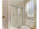 Bathroom featuring a toilet and shower with glass doors, accented by floral wallpaper and a window at 5619 Bayshore Rd # 152, Palmetto, FL 34221