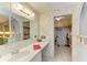Bright bathroom with a vanity, closet, mirror, and floral wallpaper, offering ample storage space at 5619 Bayshore Rd # 152, Palmetto, FL 34221