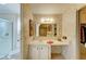 Bathroom showcasing a vanity with storage, floral wallpaper, and an arched mirror leading to the closet at 5619 Bayshore Rd # 152, Palmetto, FL 34221