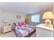 Warm bedroom featuring a bed with a quilt, a dresser with a lamp, and soft lighting at 5619 Bayshore Rd # 152, Palmetto, FL 34221