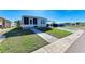 Single story home with a well maintained lawn and concrete pathway to the entry at 5619 Bayshore Rd # 152, Palmetto, FL 34221