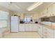 Well-lit kitchen with white appliances, white cabinets, and patterned wall paper at 5619 Bayshore Rd # 152, Palmetto, FL 34221