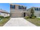 Well-maintained two-story home with a two car garage, stone accents, and a freshly mowed lawn at 5868 Calla Lilly Dr, Sarasota, FL 34232