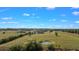 Extensive acreage featuring home, outbuildings, trees, fields, and a small pond on a partly cloudy day at 5949 225Th E St, Bradenton, FL 34211