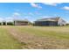Expansive backyard featuring a home with a screened porch and a large metal barn, perfect for country living at 5949 225Th E St, Bradenton, FL 34211
