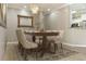 Well-lit dining room with a wooden table, six chairs, decorative rug, and a stylish chandelier at 5949 225Th E St, Bradenton, FL 34211